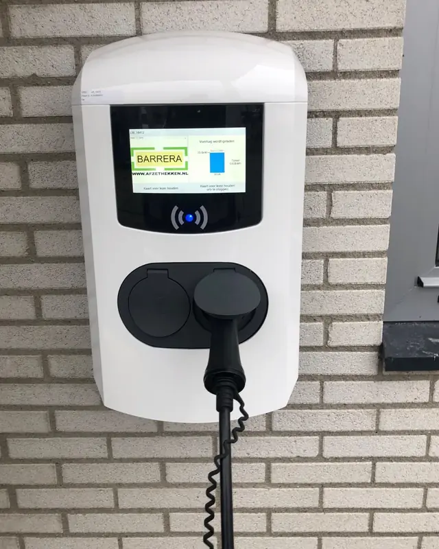 Laadpaal met display aan een bakstenen gevel