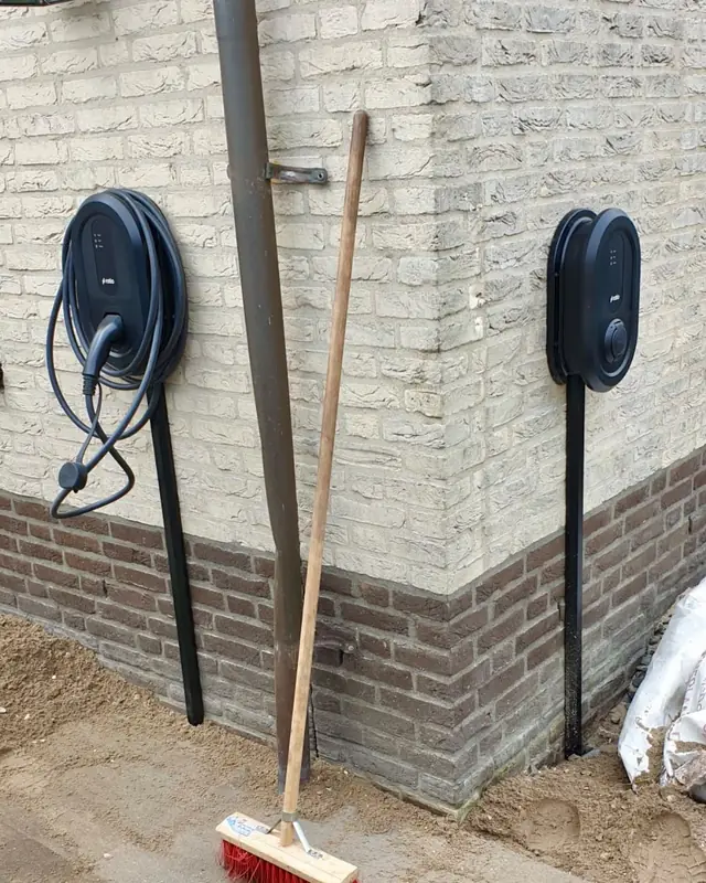 Twee laadpalen aan de hoek van een woning, net geplaatst