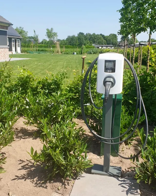 Laadpaal op een paal in een tuin