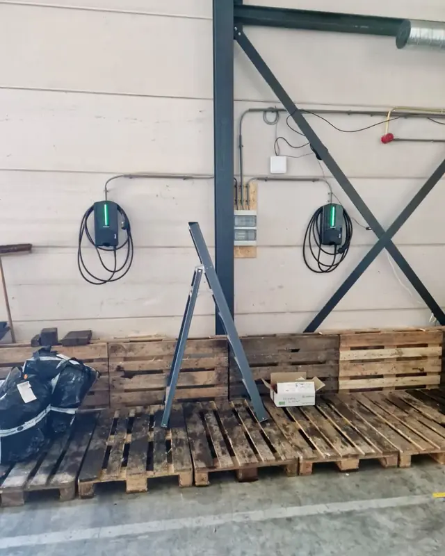 Twee laadpalen in een bedrijfshal, tijdens de installatie