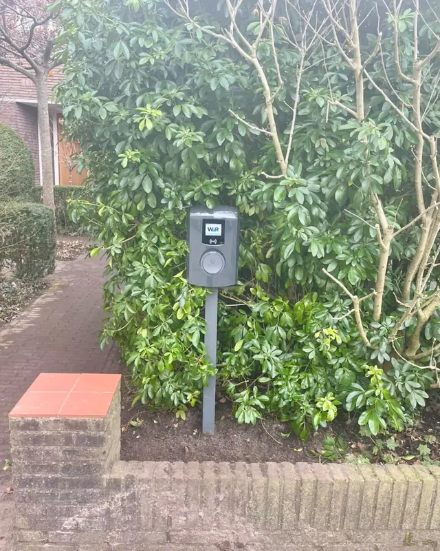 Laadpaal op een paal langs het tuinpad
