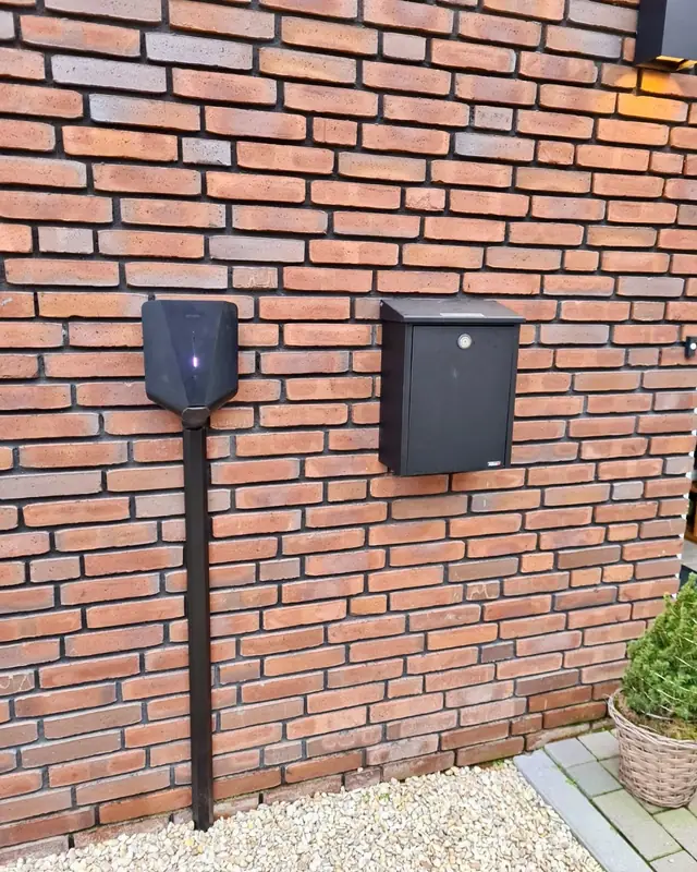 Laadpaal naast een brievenbus aan de gevel