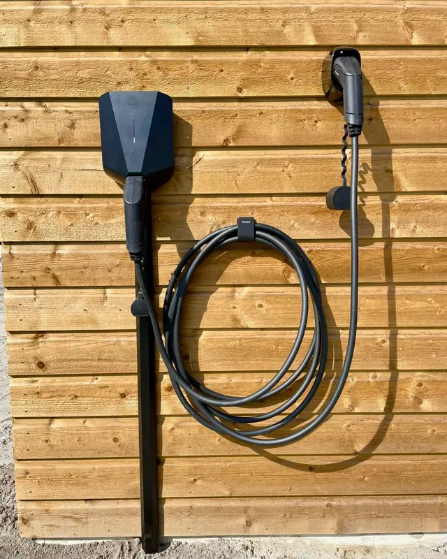 Laadpaal met kabelhouder op houten gevelbekleding