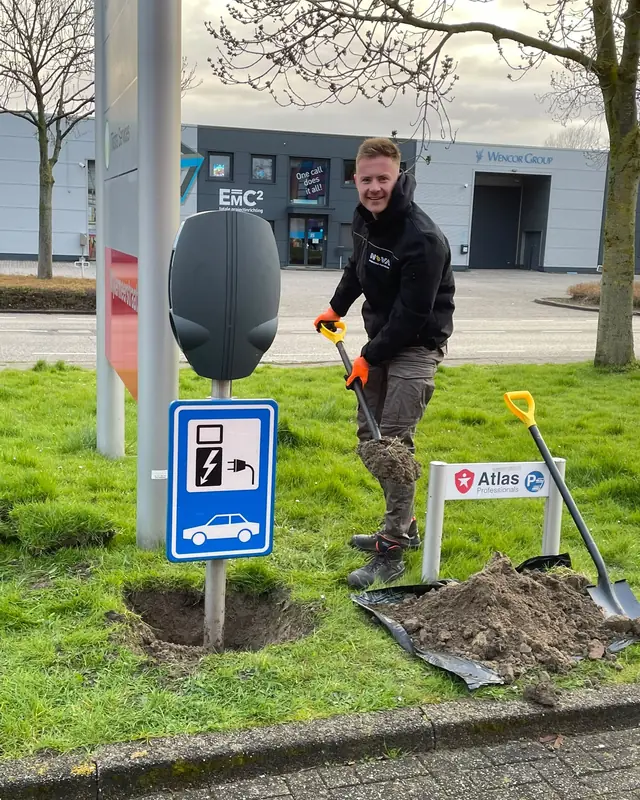 Monteur plaatst een laadpaal op een bedrijfsterrein