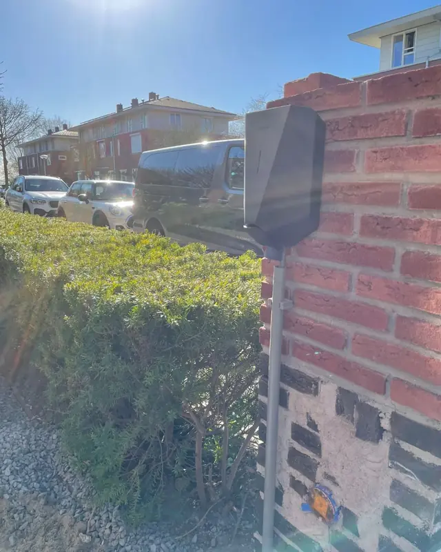 Laadpaal aan een tuinmuur