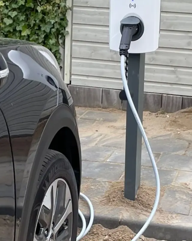 Laadpaal op een paal met een ladende auto
