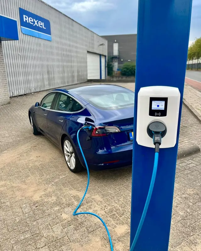 Zakelijke laadpaal bij een bedrijfspand, met een ladende auto