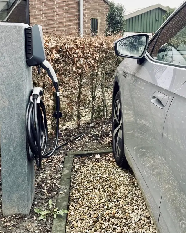 Laadpaal op een stenen zuil naast de oprit