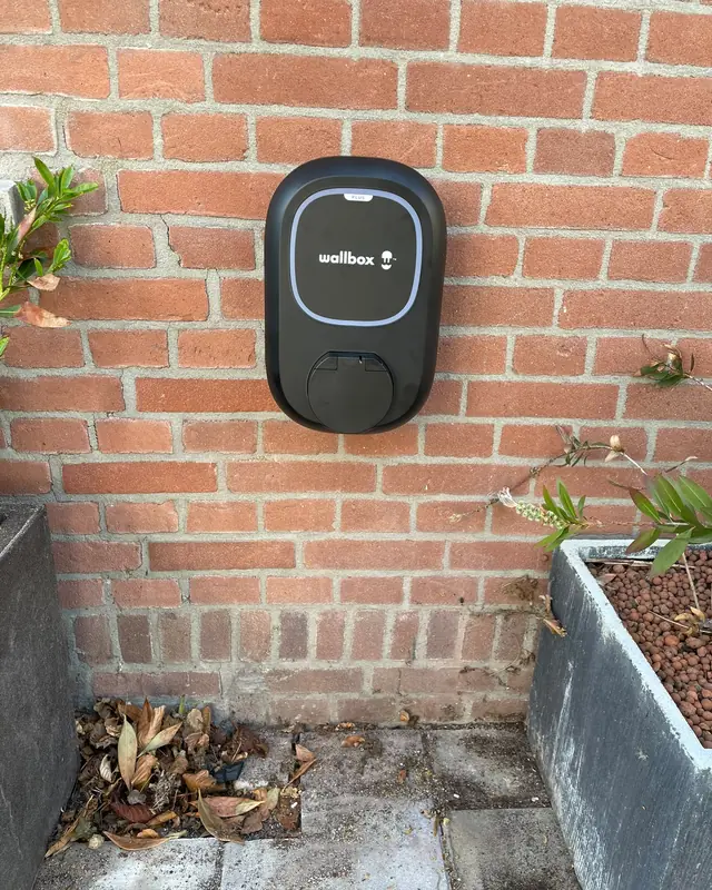 Wallbox-laadpaal aan een bakstenen muur